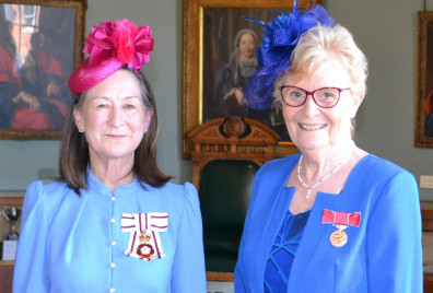 Two ladies wearing their medal honours
