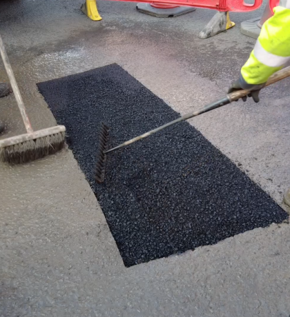Photograph of a pothole being resurfaced. 